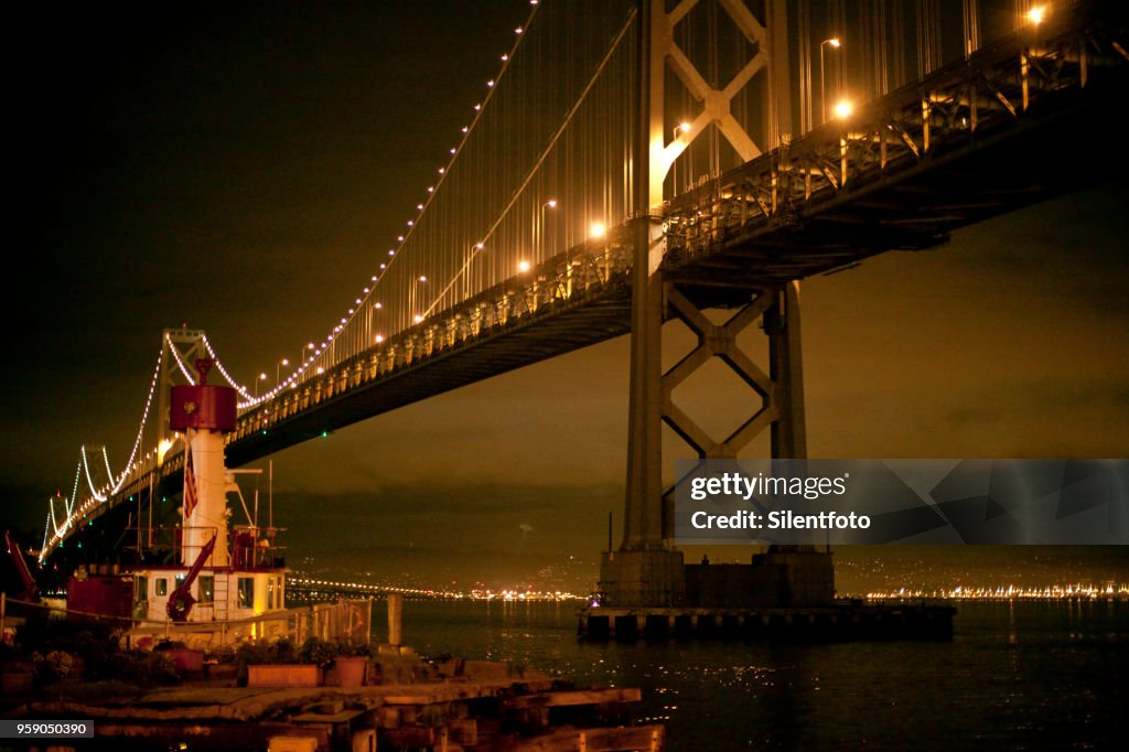The San Francisco Bay Bridge With Fire Boat Illuminated Under Night Sky