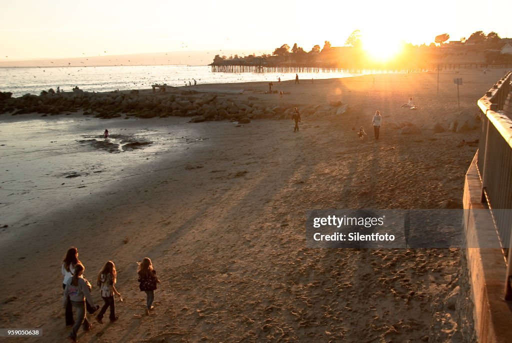 A Family Walks Along Capitola Beach As Sun Sets