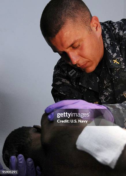 In this handout image provided by the U.S. Navy, Lt. Marlin Williams, a Navy chaplain embarked aboard the aircraft carrier USS Carl Vinson, prays for...