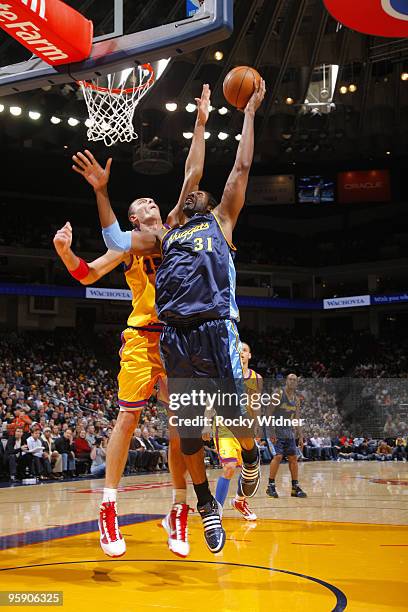 Nene Hilario of the Denver Nuggets scores on the left handed shot against Andris Biedrins of the Golden State Warriors on January 20, 2010 at Oracle...