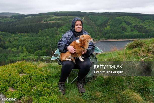 Woman sits with her dog as spectators gather on a hillside above Derwent Dam as they wait for a Lancaster bomber from the Battle of Britain Memorial...