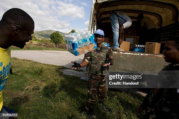 In this handout image provided by the United Nations Stabilization Mission in Haiti , Haitian volunteers and UN peacekeepers load a a truck January...