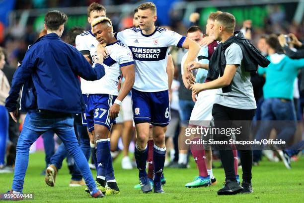 Adama Traore of Boro looks dejected with teammate Ben Gibson of Boro alongside him as Villa fans celebrate on the pitch all around them at the end of...