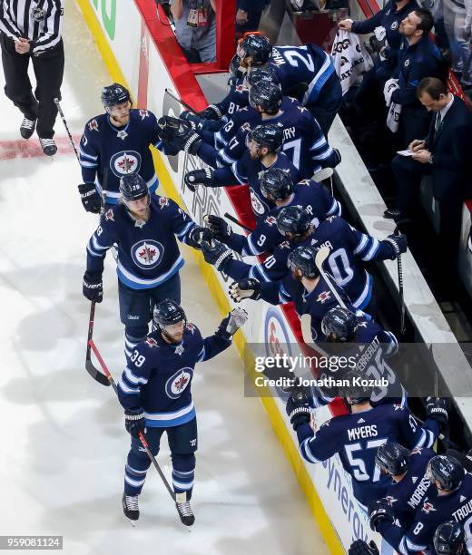 Toby Enstrom, Patrik Laine and Nikolaj Ehlers of the Winnipeg Jets celebrate a first period goal against the Vegas Golden Knights with teammates at...