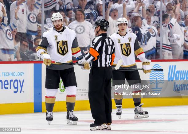 Referee Kelly Sutherland gives an explanation to James Neal and David Perron of the Vegas Golden Knights during a first period stoppage in play...