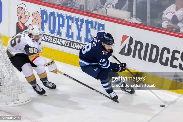 Bryan Little of the Winnipeg Jets plays the puck around the net as Erik Haula of the Vegas Golden Knights gives chase during second period action in...