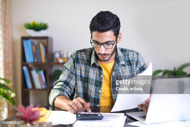 man calculating bills in home office - indian economy stock pictures, royalty-free photos & images