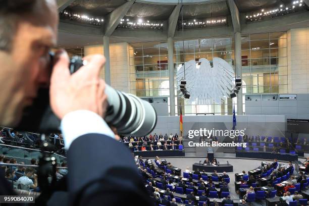 Photographer points his camera towards Angela Merkel, Germany's chancellor, during a budget policy plan debate in the lower-house of the Bundestag in...