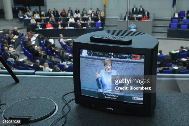 Angela Merkel, Germany's chancellor, is displayed on television monitor as she speaks to lawmakers during a budget policy plan deabte in the...
