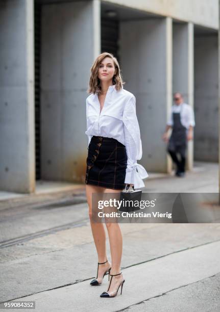 Ksenija Lukich wearing white button shirt with long sleeves, mini skirt during Mercedes-Benz Fashion Week Resort 19 Collections at Carriageworks on...