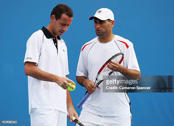 Andy Ram of Israel and Michael Llodra of France talk tactics in their first round doubles match against Julien Benneteau of France and Steve Darcis...