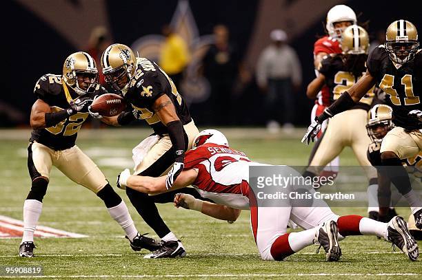Darren Sharper of the New Orleans Saints looks to stiff-arm Lyle Sendlein of the Arizona Cardinals as Sharper returns a recovered fumble for positive...