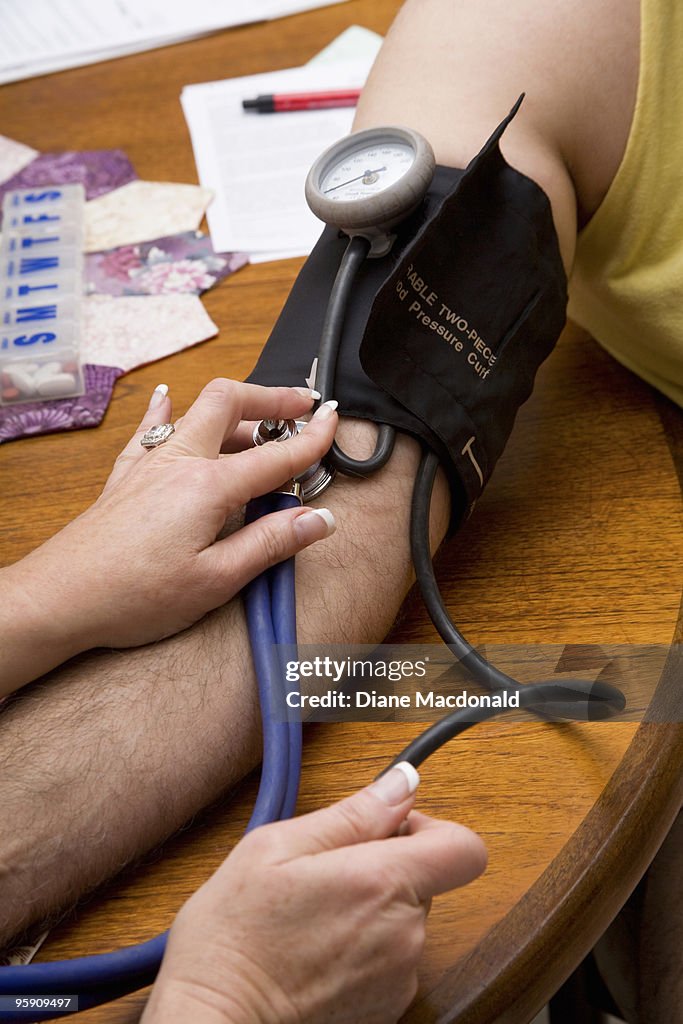 A visiting nurse taking a man's blood pressure