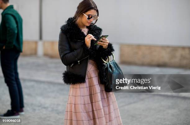 Guest wearing black jacket, salmon colored dress, black bag, mirrored sunglasses during Mercedes-Benz Fashion Week Resort 19 Collections at...
