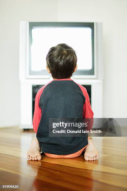 tv addiction - small child sitting on floor stock-fotos und bilder