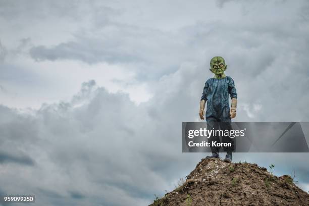 alien standing on the mountain - alien costume stock pictures, royalty-free photos & images