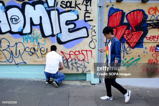 Man kneels down at a boarded-up property on the second and final day of the 2016 Notting Hill Carnival in west Londonby some accounts the 50th...