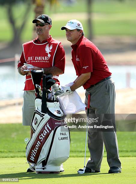 Paul Lawrie of Scotland waits with his caddie Andy Forsyth on the ninth hole during the first round of The Abu Dhabi Golf Championship at Abu Dhabi...