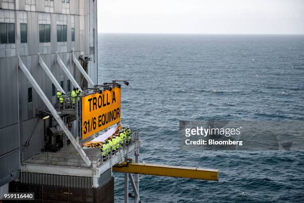 Workers unveil the new Equinor name on the Troll A natural gas platform, operated by Equinor ASA, in the North Sea, Norway, on Wednesday, May 16,...