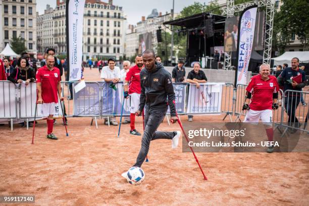 Eric Abidal plays soccer with crutches during his visit at European Amputee Football Federation at the Fan Zone ahead of the UEFA Europa League Final...