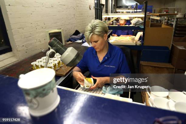 Vicky Bostock applies a lithography on a cup as part of a special collection ahead of the wedding of Prince Harry and Meghan Markle at William...