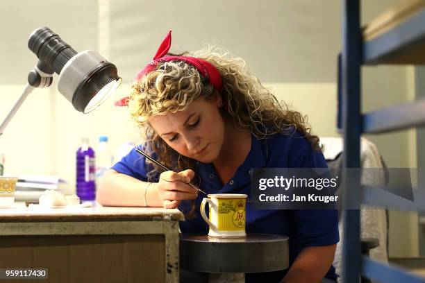 Nicola Gilchrist applies gilding to a cup as part of a special collection ahead of the wedding of Prince Harry and Meghan Markle at William Edwards...