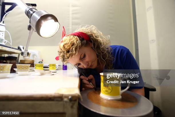 Nicola Gilchrist applies gilding to a cup as part of a special collection ahead of the wedding of Prince Harry and Meghan Markle at William Edwards...