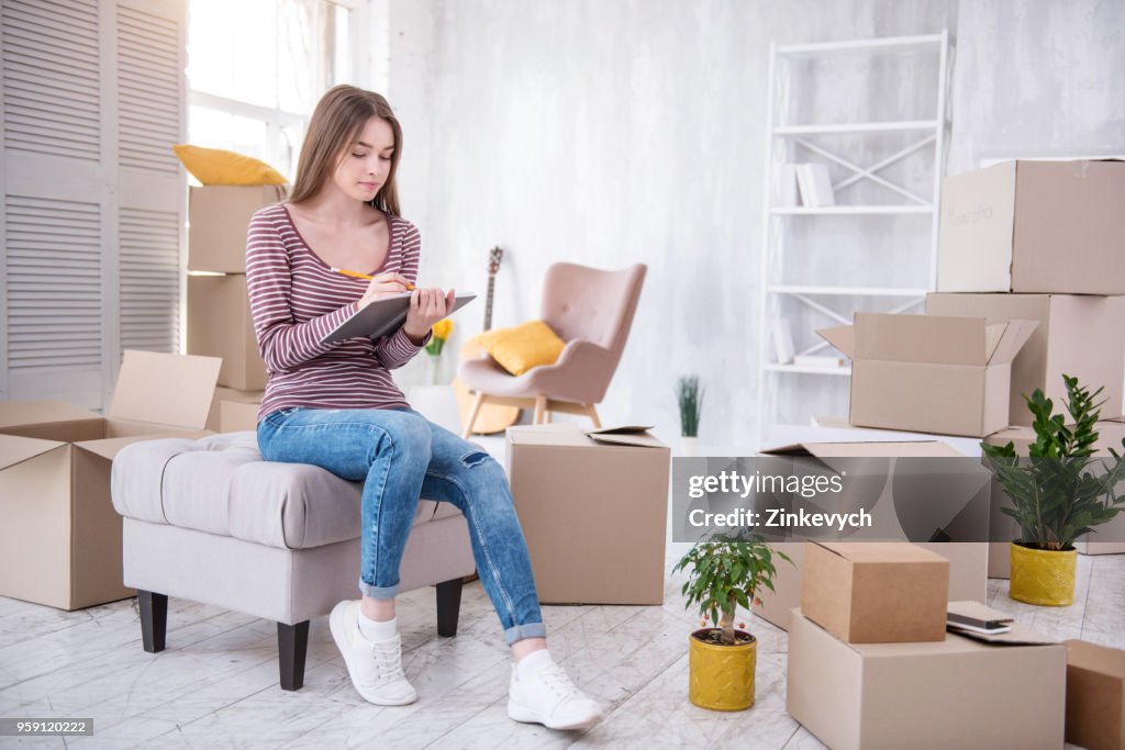 Charming young woman checking list of boxes