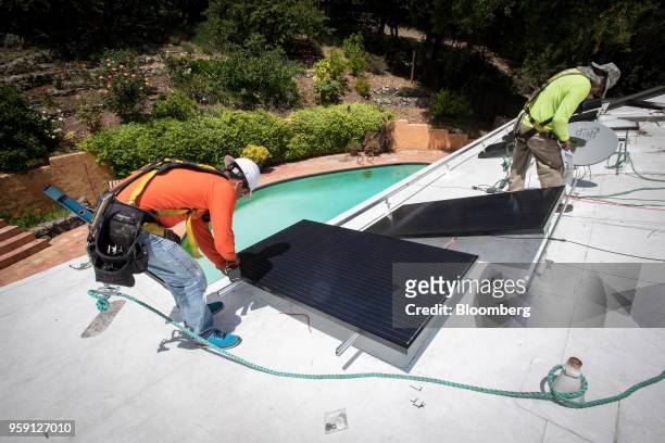PetersenDean Inc. Employees install solar panels on the roof of a home in Lafayette, California, U.S., on Tuesday, May 15, 2018. California became...