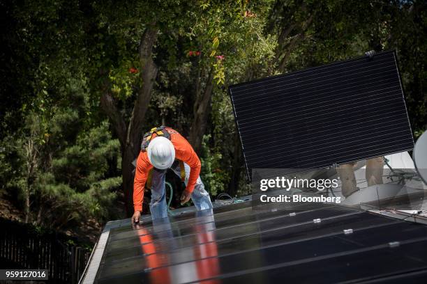 PetersenDean Inc. Employees install solar panels on the roof of a home in Lafayette, California, U.S., on Tuesday, May 15, 2018. California became...