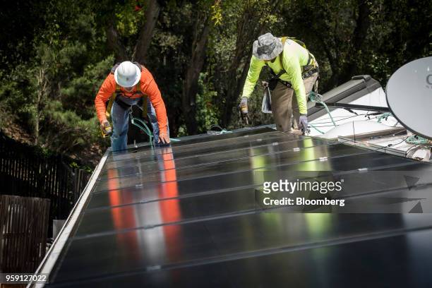 PetersenDean Inc. Employees install solar panels on the roof of a home in Lafayette, California, U.S., on Tuesday, May 15, 2018. California became...