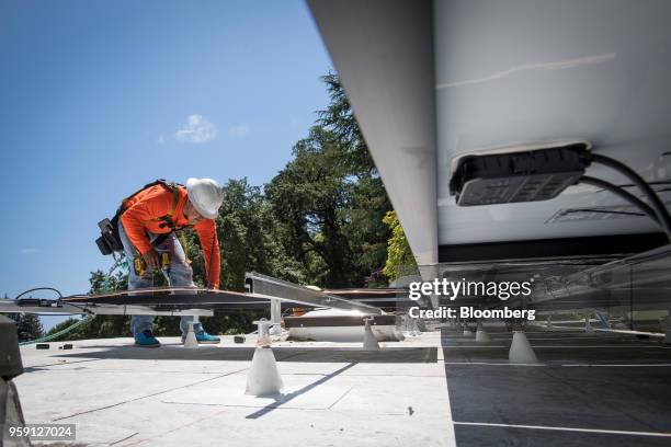 PetersenDean Inc. Employee installs a solar panel on a home in Lafayette, California, U.S., on Tuesday, May 15, 2018. California became the first...