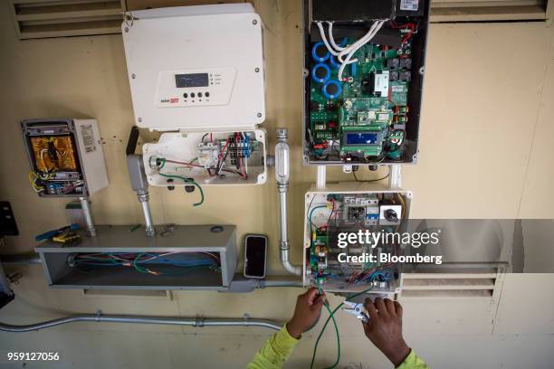 PetersenDean Inc. Employee installs wiring for a solar inverter on a home in Lafayette, California, U.S., on Tuesday, May 15, 2018. California became...