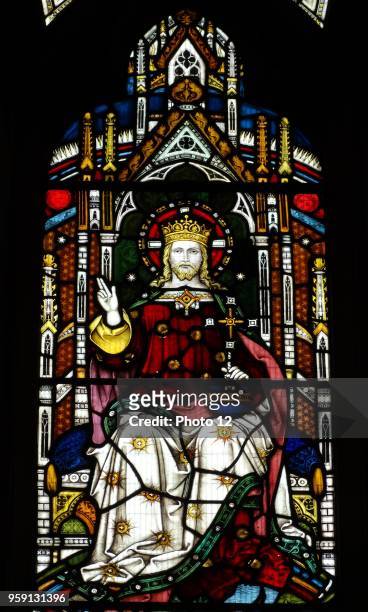 Stained glass window at St Michael and All Angels Anglican church, in Hughenden, Buckinghamshire, England. The window depicts Christ enthroned....