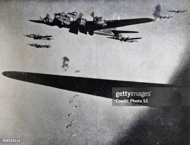 Photograph of Boeing B-17 Flying Fortresses dropping bombs during the Second World War. Dated 1941.