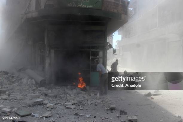 Civil defence crews and locals extinguish a fire that broke out after airstrikes hit residential areas of Jisr al-Shughur in the northwestern Idlib...