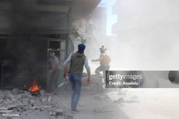 Civil defence crews and locals extinguish a fire that broke out after airstrikes hit residential areas of Jisr al-Shughur in the northwestern Idlib...