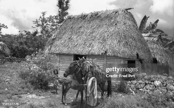 Two girls with their mules in front of the house in a small village.