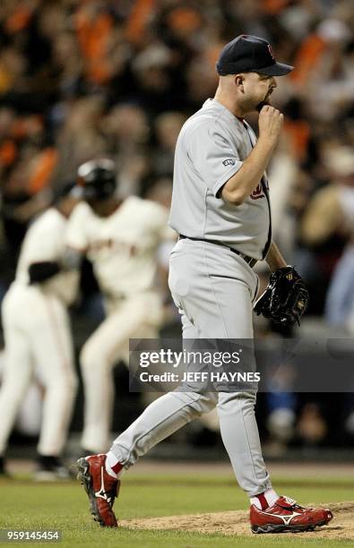 Relief pitcher Rick White of the St. Louis Cardinals walks back to the mound while Benito Santiago of San Francisco Giants circles the bases on his...