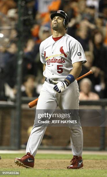 Albert Pujols of the St. Louis Cardinals walks back to the dugout after striking out in the 9th inning against the San Francisco Giants celebrates...