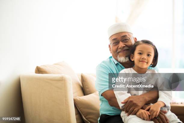 portrait of a senior muslim man with his granddaughter - two young arabic children only indoor portrait stock pictures, royalty-free photos & images