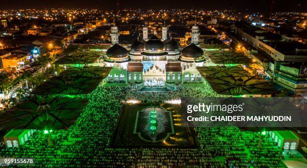 In this photograph taken by a drone shows Indonesian Muslims pray during the start of the holy month of Ramadan at the Baiturrahman Mosque in Banda...