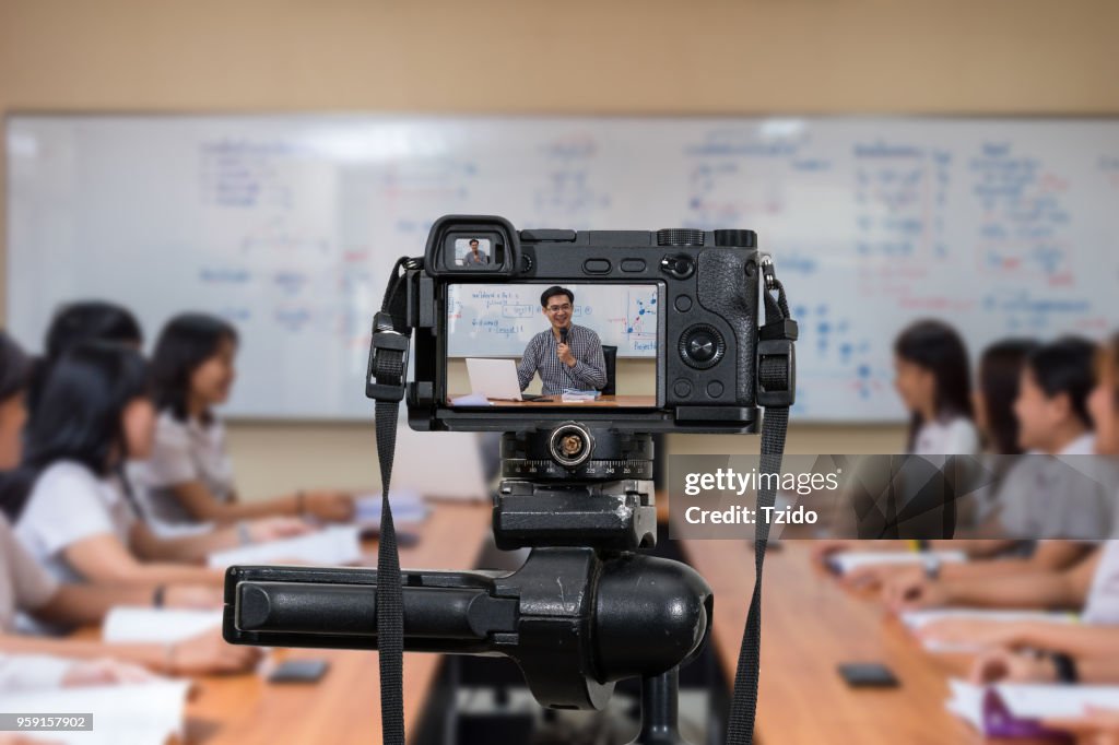 Professional digital Mirrorless camera on the tripod recording video blog of Asian teacher in the classroom, Camera for photographer or Video and Technology Live Streaming concept, University education concept