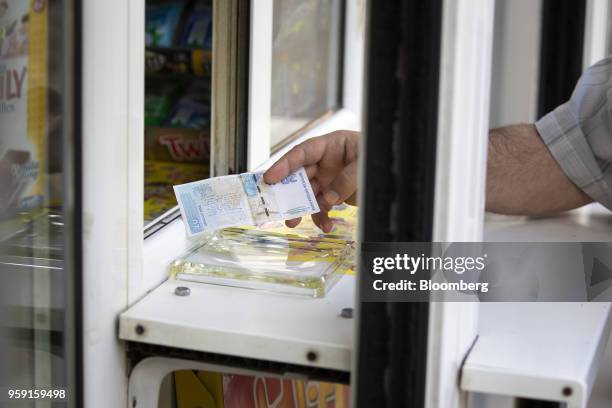 Customer hands over a 20 lev banknote at a snack kiosk counter in Sofia, Bulgaria, on Wednesday, May 16, 2018. The EU's poorest-nation, which holds...