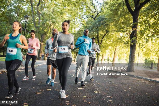 gruppe von menschen laufstrecke zusammen in einem park - marathon stock-fotos und bilder