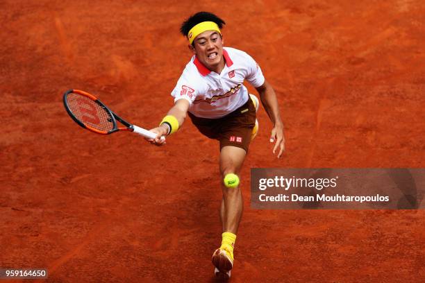Kei Nishikori of Japan stretches and returns a forehand in his match against Grigor Dimitrov of Bulgaria during day 4 of the Internazionali BNL...