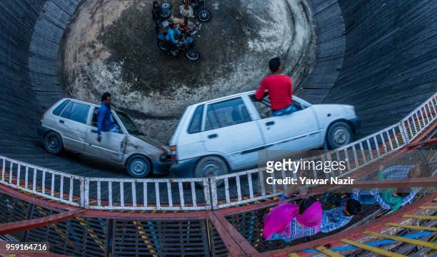 Stunt drivers daredevils perform in the well of death on May 15, 2018 in Srinagar, the summer capital of Indian administered Kashmir, India. The...