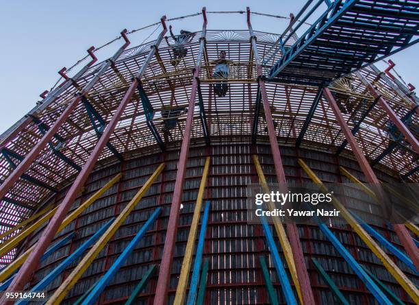 The audience stands upon the platform built around the circumference of the structure and gaze down into the well of death on May 15, 2018 in...