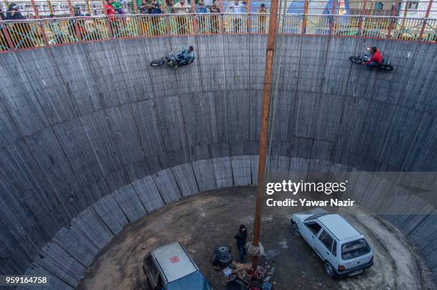Stunt motorcyclist daredevils perform in the well of death on May 15, 2018 in Srinagar, the summer capital of Indian administered Kashmir, India. The...