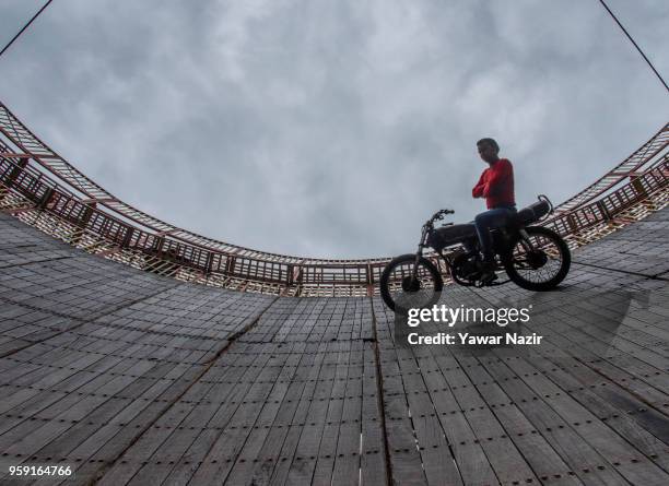 Stunt motorcyclist daredevil performs in the well of death on May 15, 2018 in Srinagar, the summer capital of Indian administered Kashmir, India. The...